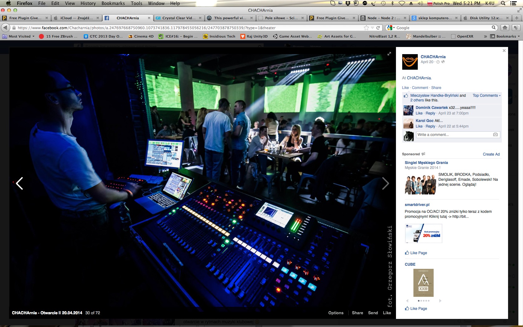 DJ pracujący na konsolecie w klubie oświetlonym na niebiesko, w tle widoczni ludzie przy stolikach. Konsoleta z licznymi przyciskami i ekranami.