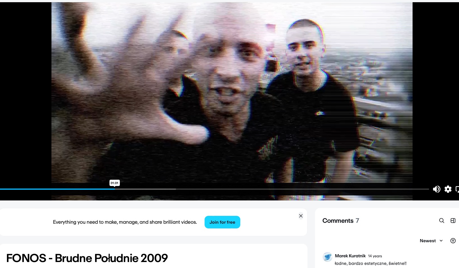 Kadr z teledysku z trzema raperami. Jeden z nich wyciąga rękę w stronę kamery. Widoczny pasek odtwarzania wideo, co sugeruje zatrzymany kadr z filmu.