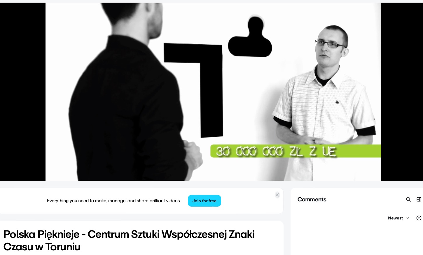 Ujęcie z czarno-białego filmu: dwóch mężczyzn, jeden w czarnej marynarce, drugi w jasnej koszuli, logo i napis '30 000 000 ZŁ Z UE' na zielonym pasku.