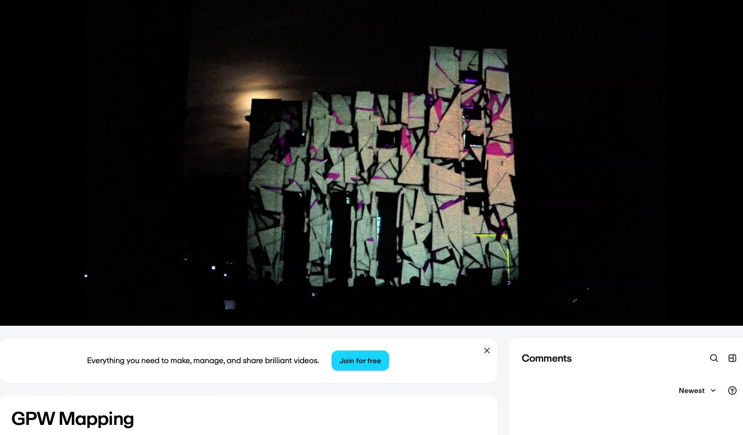Nocne widowisko: budynek z projekcją mappingu 3D w abstrakcyjne wzory, podświetlony księżycem w tle, sylwetki widzów w dolnej części kadru, ciemna sceneria.