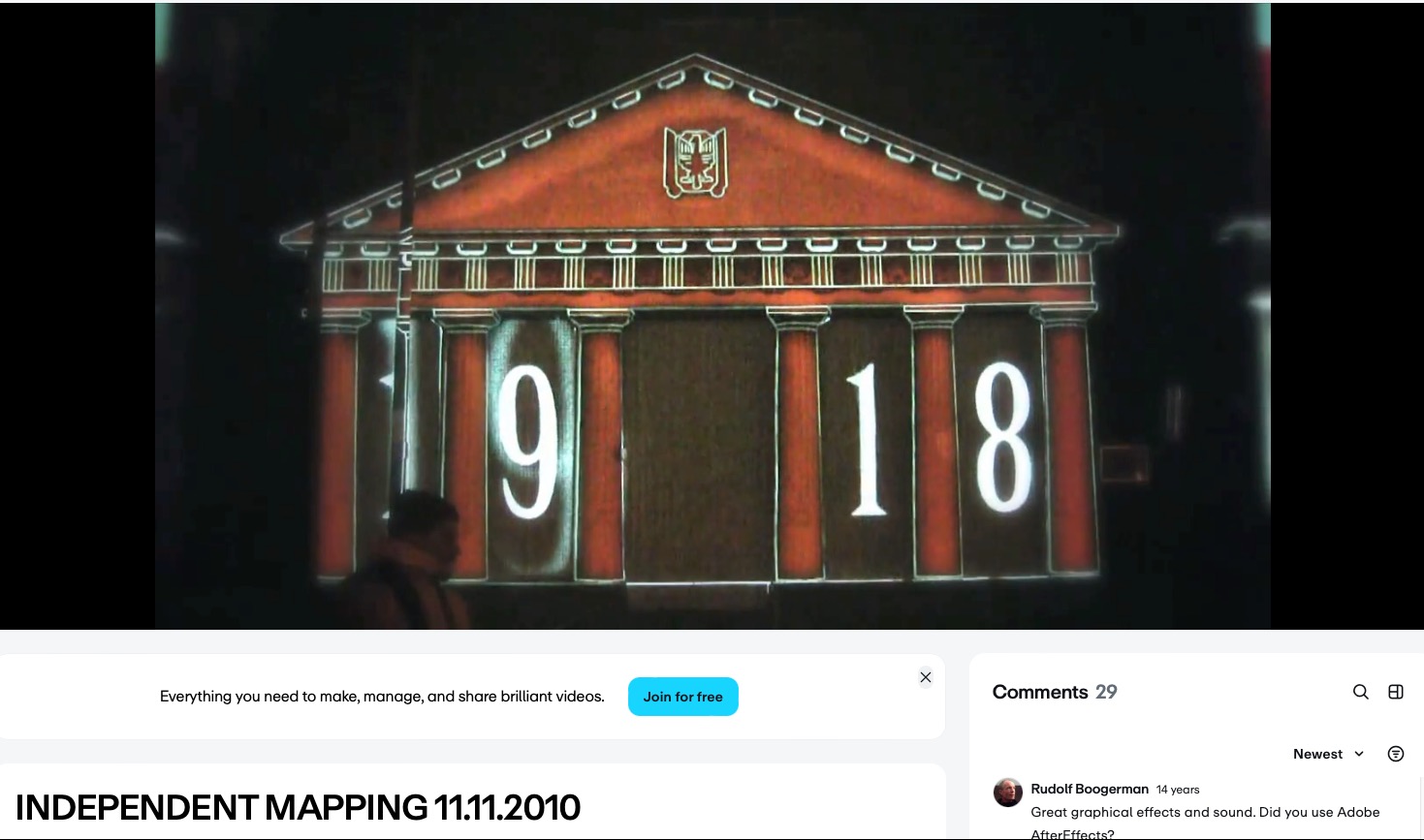 Iluminacja budynku w stylu antycznym z liczbą 1918, prawdopodobnie w ramach mappingu. Widoczna osoba w lewym dolnym rogu kadru. Ciemne tło.