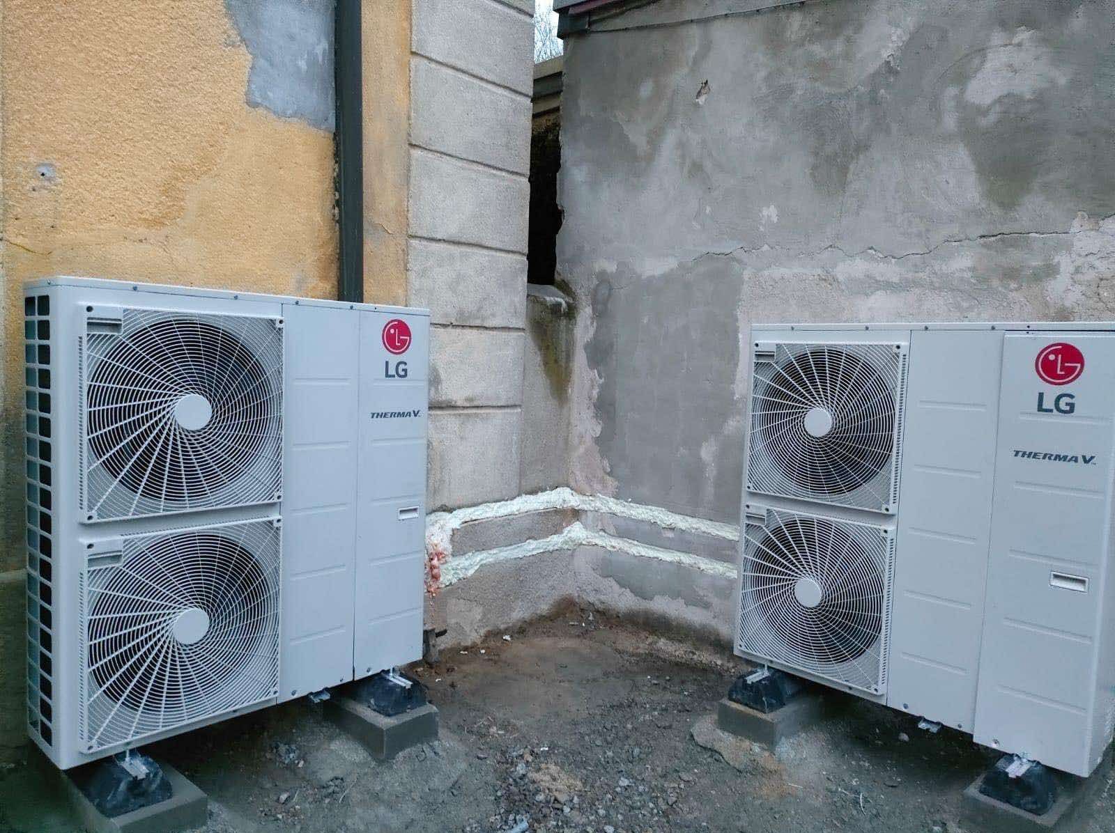 Dwa agregaty pompy ciepła LG Therma V zamontowane na betonowych podstawach przy ścianach budynku, z widocznym uszczelnieniem pianką montażową.