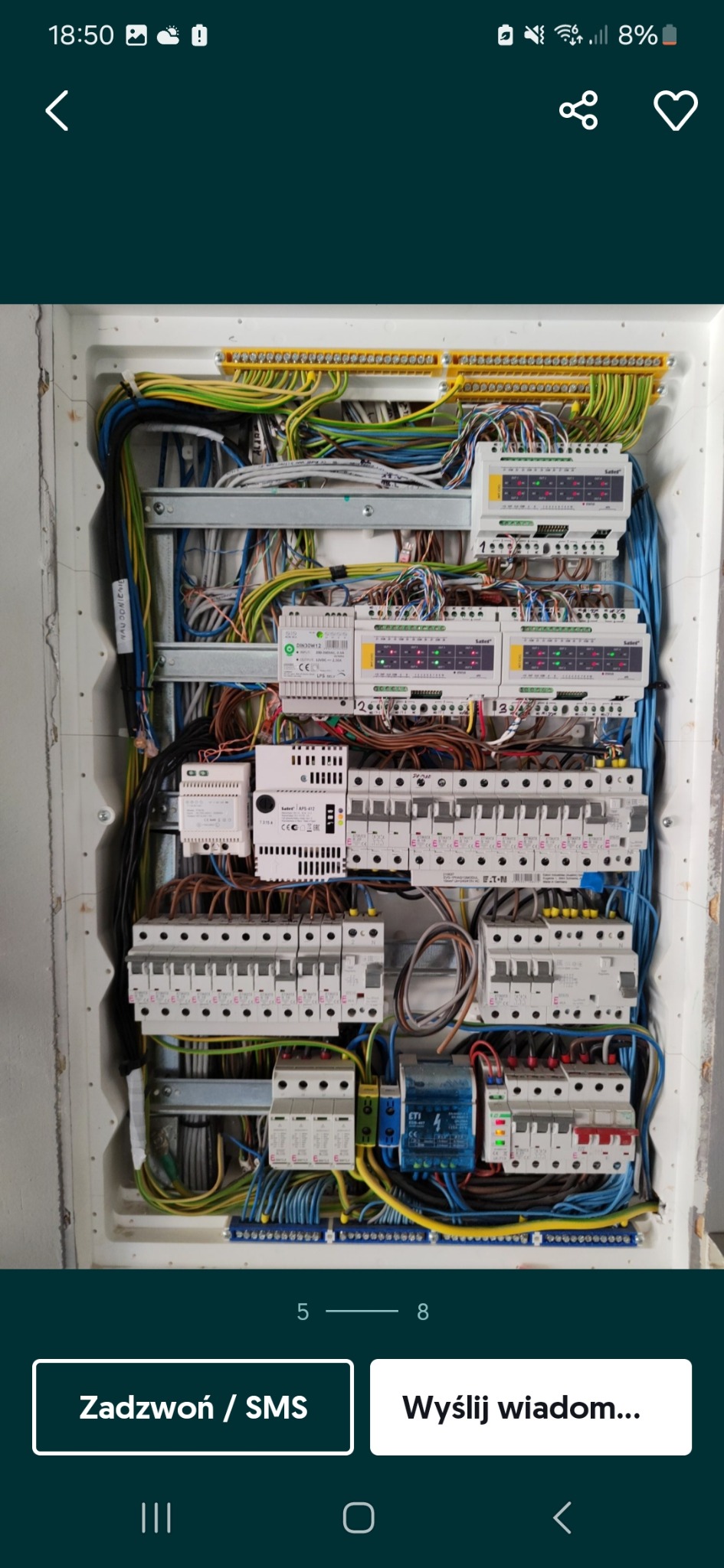 Rozdzielnica elektryczna z licznymi przewodami, bezpiecznikami i modułami sterującymi, widoczne elementy montażowe i okablowanie. Układ w skrzynce, instalacja wewnętrzna.