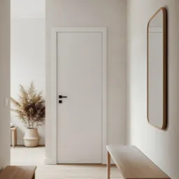 Jasne wnętrze przedpokoju z drewnianą podłogą, białą ramą drzwi i ławką. Minimalistyczny design z lustrem i suszoną trawą w koszu.