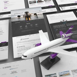 Summit Studio Marcin Charków - Prezentacja stron internetowych z motywem lotniczym, w tym model samolotu. Układ mockupów na biurku, z dominującą kolorystyką bieli, fioletu i szarości.