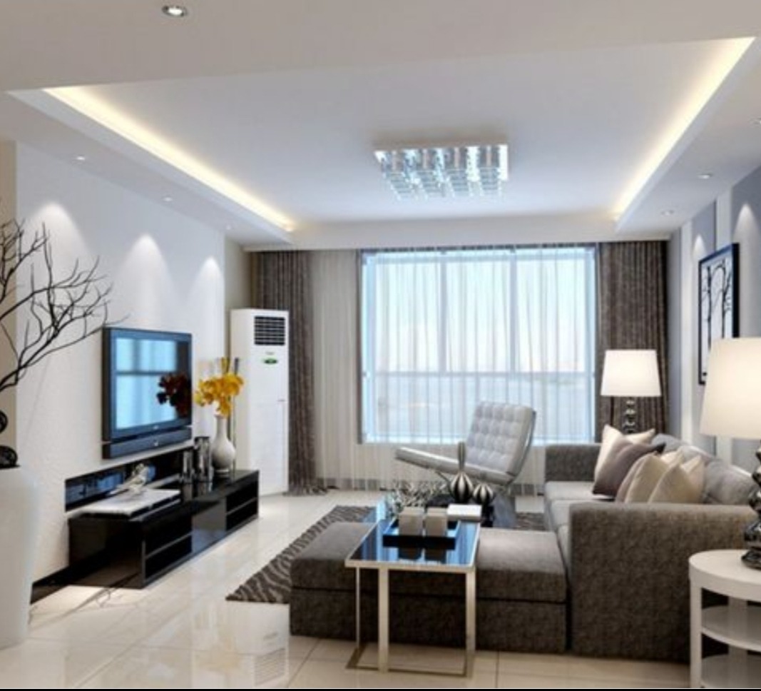 Nowoczesny salon z podwieszanym sufitem i oświetleniem LED. Jasne wnętrze z szarymi meblami i dużym oknem. Minimalistyczny design i eleganckie wykończenie.