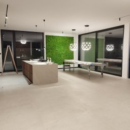 ArtDeco Renovations - Wnętrze w trakcie wykańczania: wyspa kuchenna z drewnianymi szufladami, zabezpieczone meble, drabina i ściana z mchu. Nowoczesne lampy wiszące.