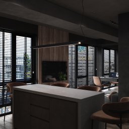 GAMKO+PARTNERS Sp. z o.o. - Nowoczesne wnętrze z wyspą kuchenną, brązowymi krzesłami barowymi i dużymi oknami z żaluzjami. Minimalistyczna lampa sufitowa. Widok na salon z biurkiem i laptopem.