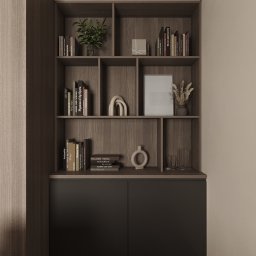 GAMKO+PARTNERS Sp. z o.o. - Minimalistyczna zabudowa meblowa z półkami z książkami i dekoracjami, utrzymana w stonowanej kolorystyce brązów i szarości. Element aranżacji wnętrza.
