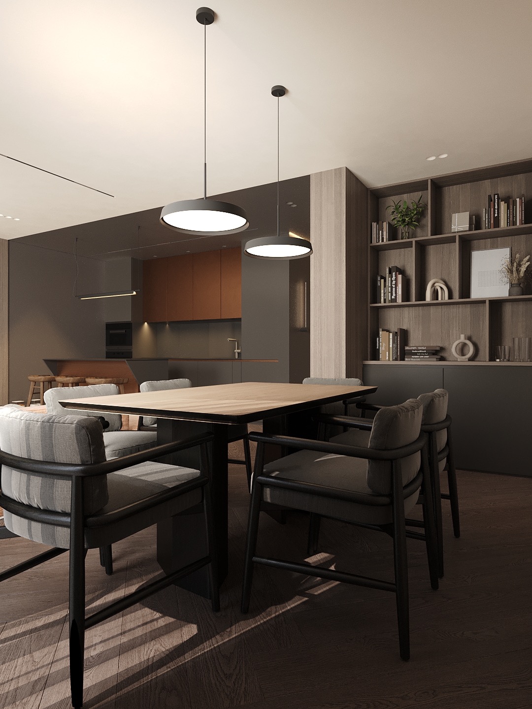 Nowoczesna jadalnia z drewnianym stołem i krzesłami z szarymi poduszkami. W tle regał z książkami i dekoracjami, oświetlona przez wiszące lampy.