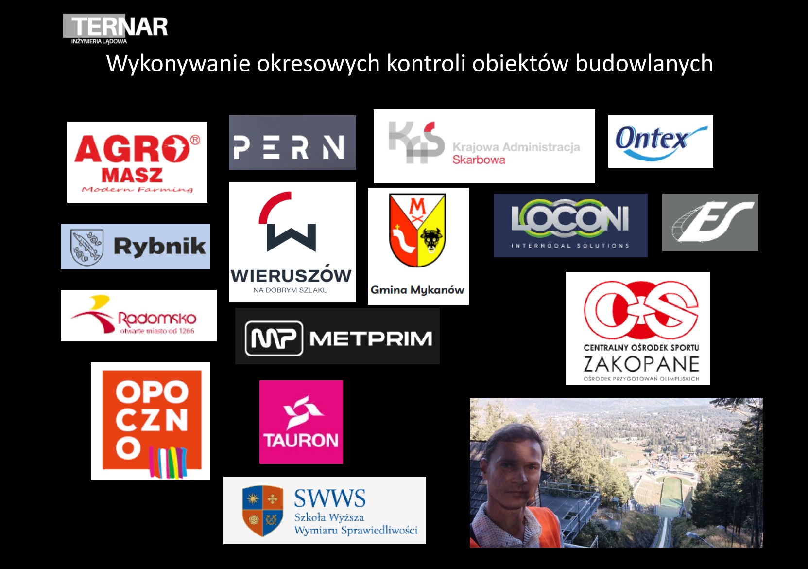 Tablica informacyjna z logotypami firm i miast, widoczna osoba w pomarańczowej kamizelce na tle skoczni narciarskiej w Zakopanem.