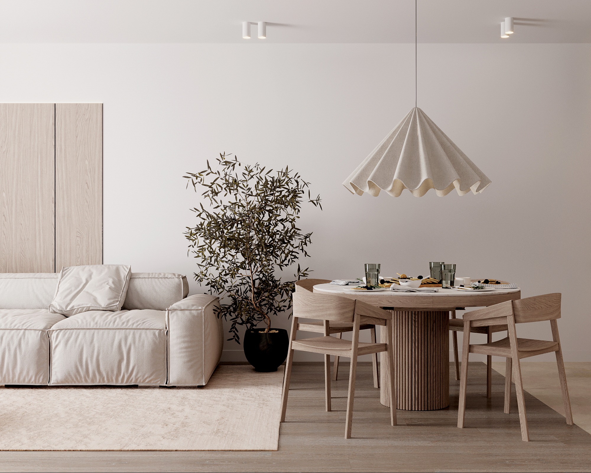 Jasne, minimalistyczne wnętrze: sofa, okrągły stół z krzesłami, roślina doniczkowa. Neutralna kolorystyka, miękkie światło, lampa wisząca z tkaniny.