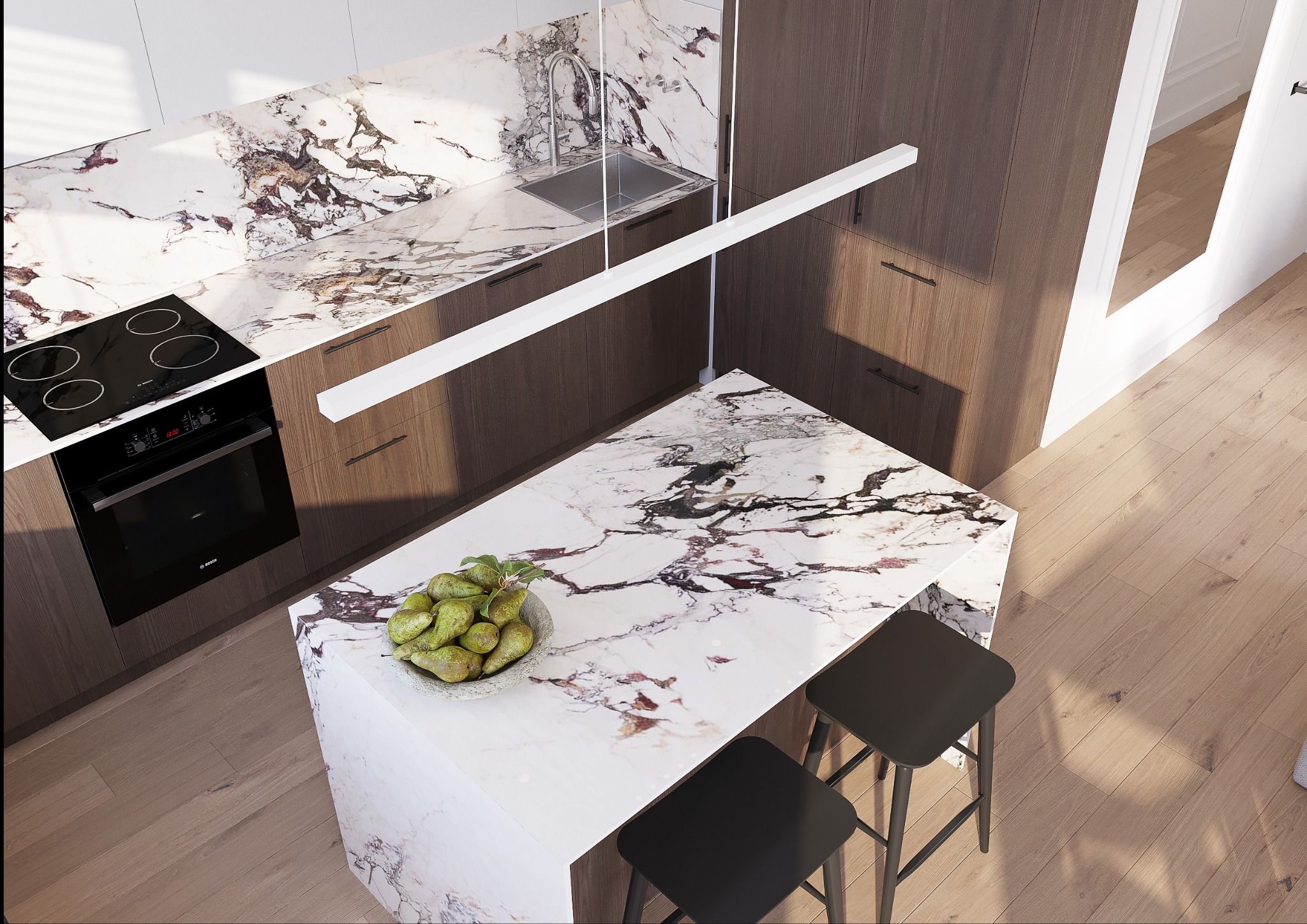 Nowoczesna kuchnia z wyspą i blatem z marmuru. Na wyspie misa z gruszkami, w tle płyta indukcyjna i zlew. Minimalistyczne oświetlenie.
