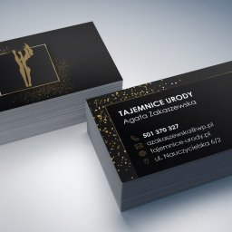 CLICK MADE KAROLINA WCISŁO - Stosy czarno-złotych wizytówek z logo figury kobiety w kwadracie, prezentujące dane kontaktowe 'Tajemnice Urody' Agaty Zakaszewskiej, na gładkim tle.