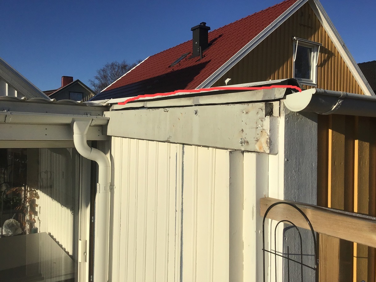 Fragment elewacji domu z widocznym systemem rynnowym, uszkodzonym narożnikiem i widoczną konstrukcją dachu w słoneczny dzień.