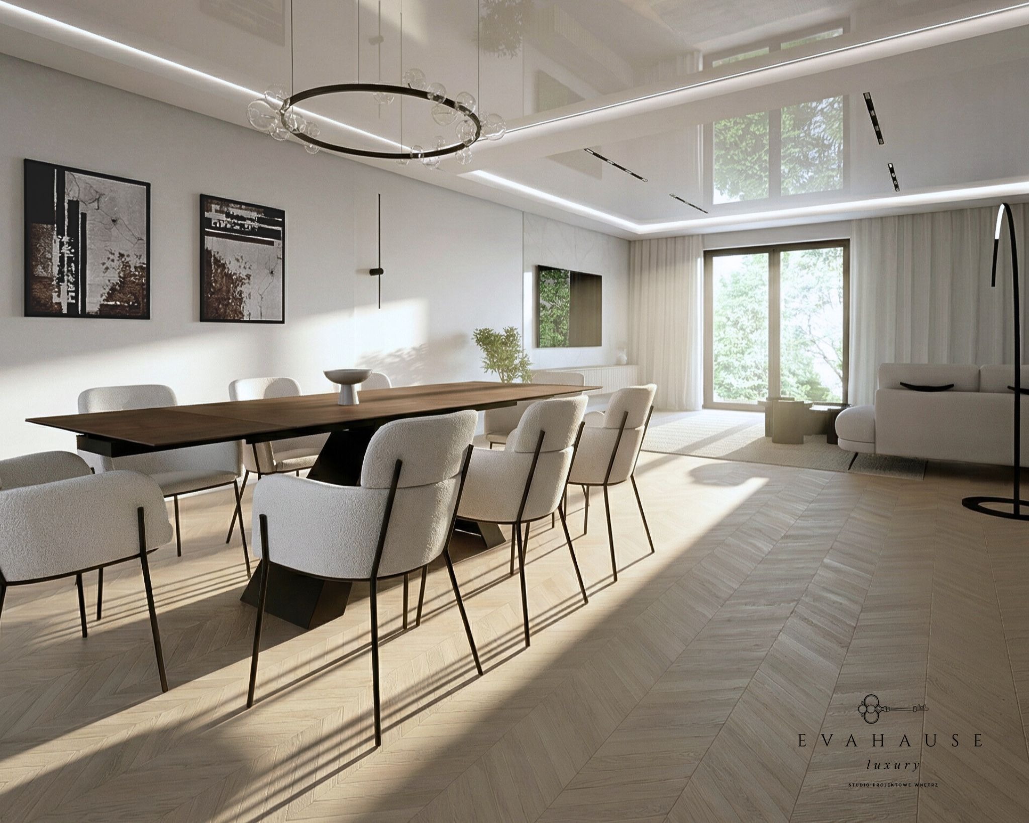 Jasne wnętrze jadalni z parkietem w jodełkę, długim stołem z ciemnym blatem i białymi krzesłami. Nad stołem okrągła lampa. W tle salon z dużym oknem.