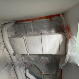 NEXTHOME KOVALEVYCH SPÓŁKA Z OGRANICZONĄ ODPOWIEDZIALNOŚCIĄ - Zabezpieczony folią fragment instalacji wentylacyjnej w trakcie prac wykończeniowych. Widoczne elementy z płyty karton-gips i taśmy malarskie.