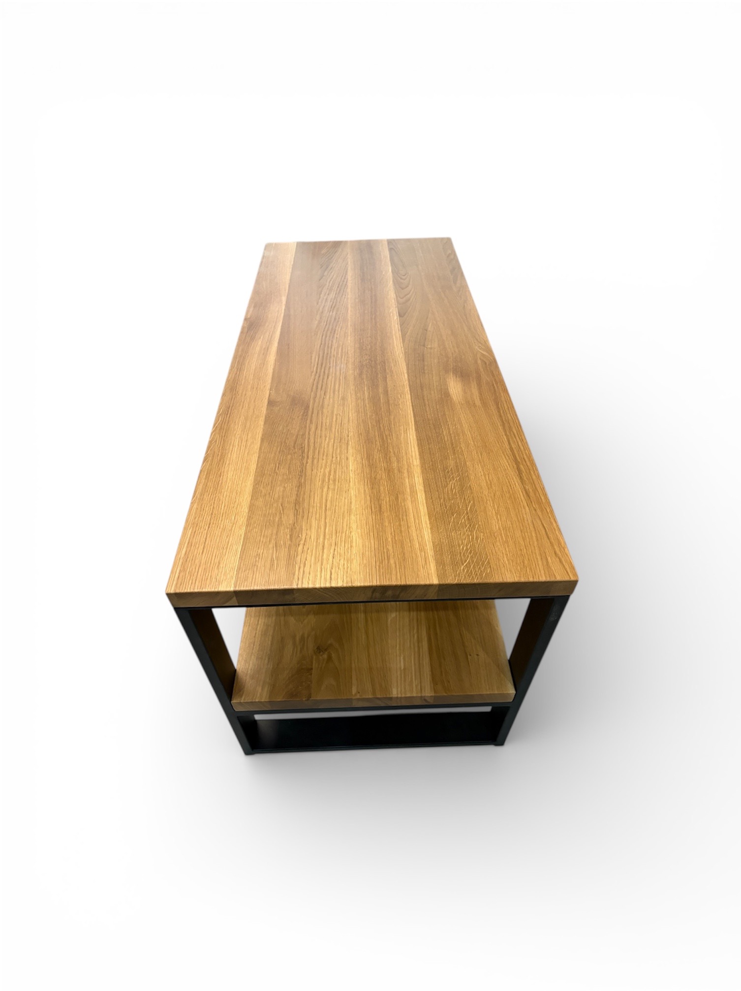 Stolik kawowy z blatem z jasnego drewna i czarną, metalową ramą, widziany z góry na białym tle. Minimalistyczny design, wyraźny rysunek słojów drewna.