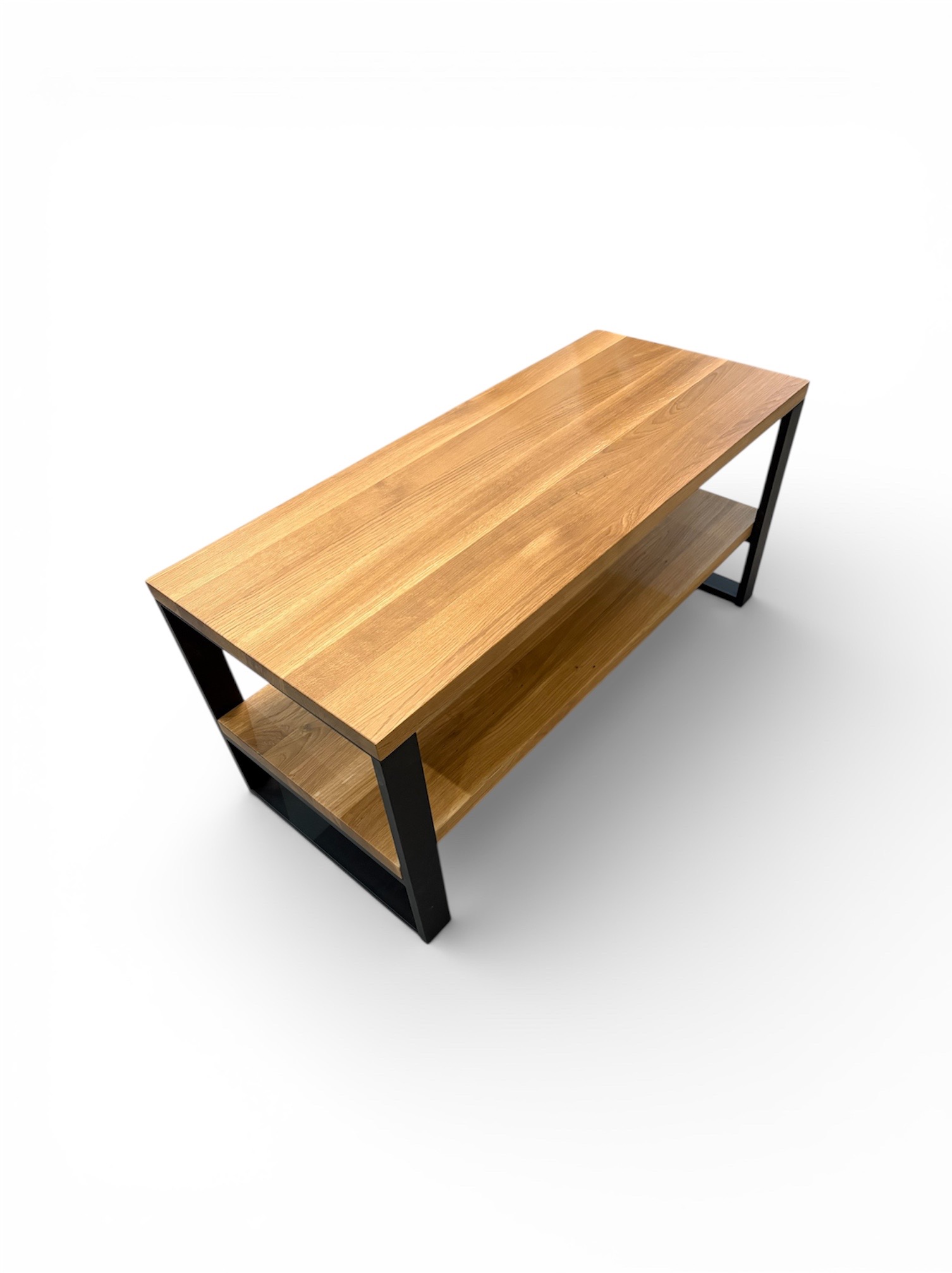 Drewniany stolik RTV z dwiema półkami i czarną, metalową ramą na białym tle. Blat z wyraźnym usłojeniem. Minimalistyczny design, nowoczesny styl.