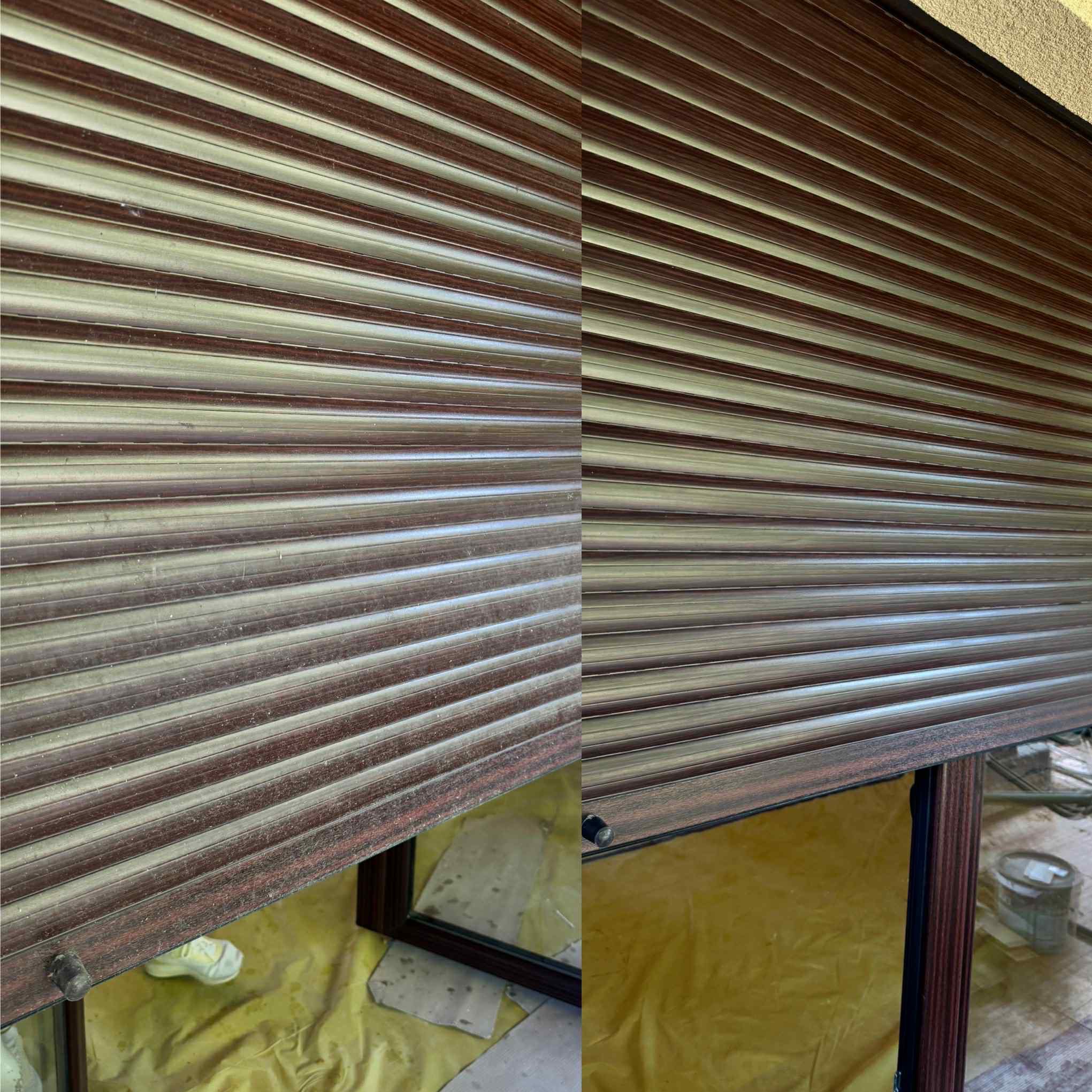 Brudne, częściowo opuszczone rolety zewnętrzne w kolorze brązowo-beżowym, widoczne ślady kurzu i zaniedbania. W tle okno zabezpieczone folią malarską.