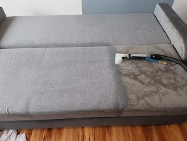 Szary narożnik w trakcie czyszczenia parowego; widoczna różnica w odcieniu po użyciu dyszy z wężykiem. Część powierzchni już wyczyszczona, reszta czeka na zabieg.