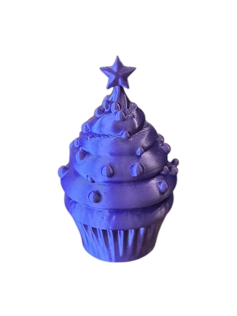 Fioletowa figurka babeczki ze gwiazdą na szczycie, wydrukowana w technologii FDM, widoczne warstwy druku 3D.