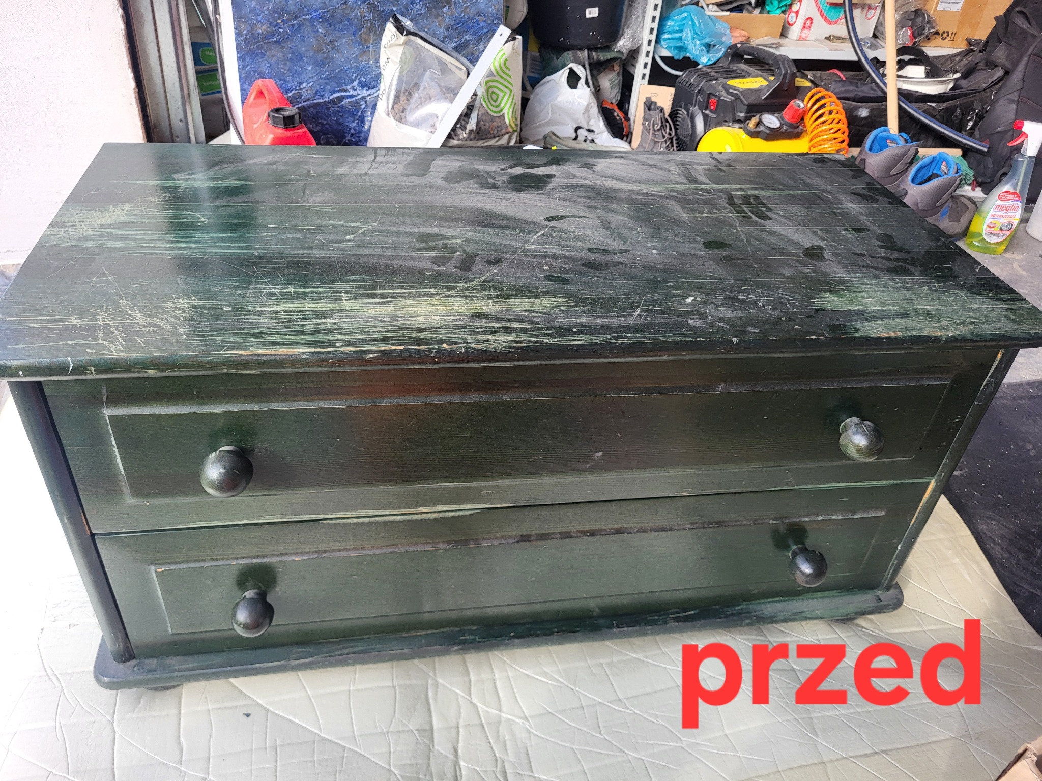 Zdjęcie komody z dwiema szufladami w odcieniach zieleni, z widocznymi śladami użytkowania i napisem „przed” w prawym dolnym rogu.