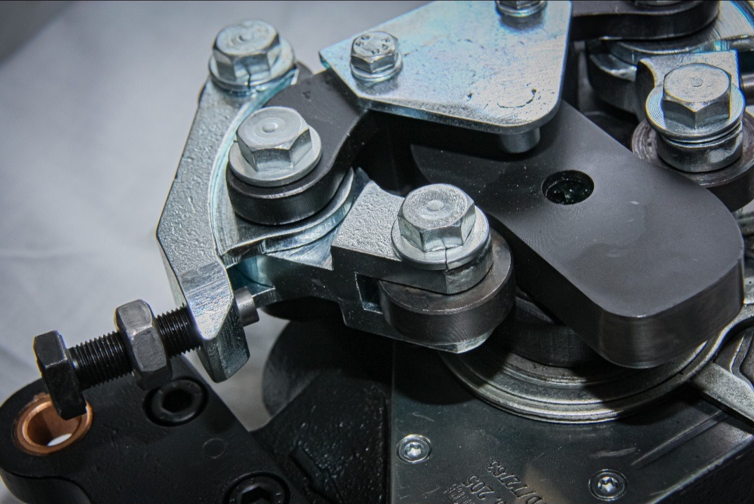 Precyzyjny detal metalowy: srebrne i czarne elementy połączone śrubami, ukazujące dokładność wykonania i dbałość o szczegóły.