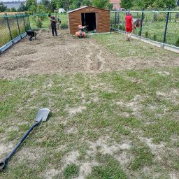 ZIELONY PATROL - Działka po przekopaniu glebogryzarką, przygotowana pod nasadzenia. W tle pracownicy i narzędzia ogrodnicze.