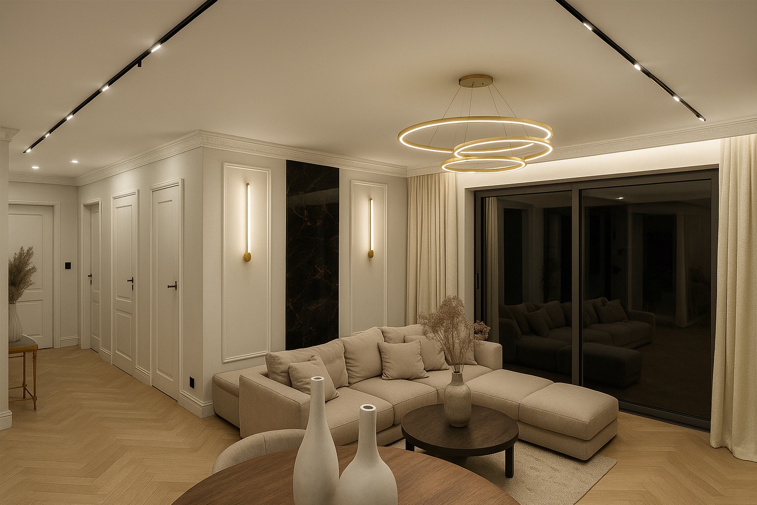 Elegancki salon z beżową sofą narożną, okrągłym stolikiem kawowym i dekoracyjnymi wazonami. Oświetlenie punktowe i okrągły żyrandol dodają wnętrzu ciepła. Parkiet w jodełkę.