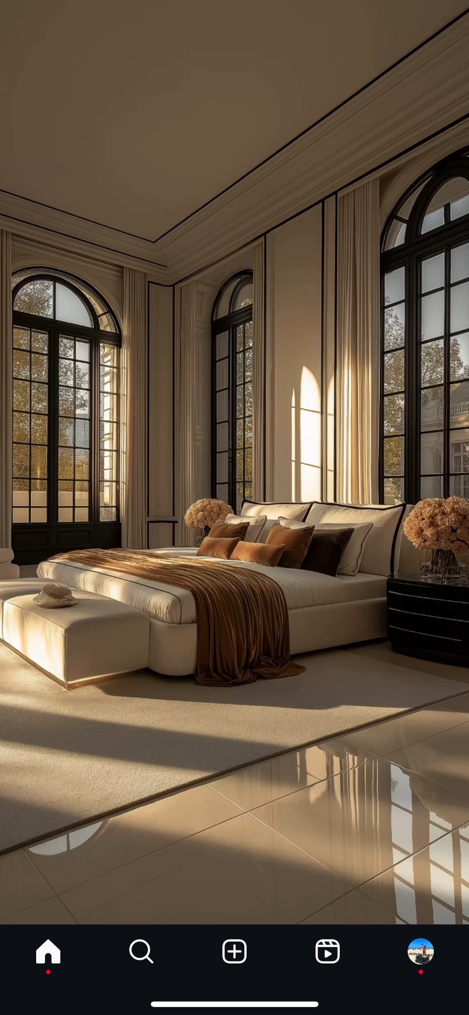 Elegancka sypialnia w bieli i brązie. Duże okna łukowe z czarnymi ramami wpuszczają promienie słoneczne na beżową podłogę i łóżko z aksamitnym pledem.