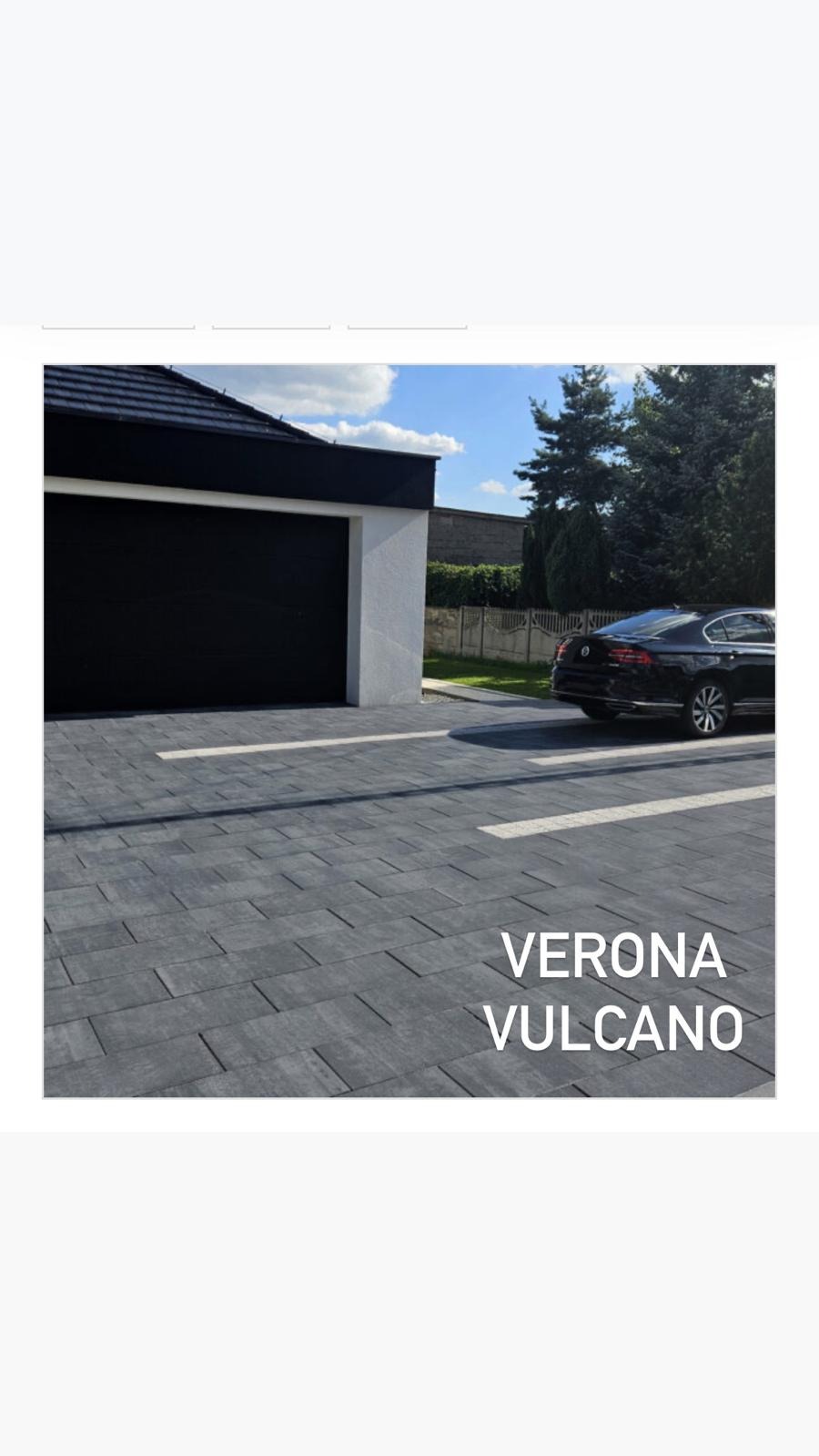 Kostka brukowa Verona Vulcano ułożona przed garażem z czarną bramą, na podjeździe stoi czarny samochód osobowy. Widoczne drzewa w tle.