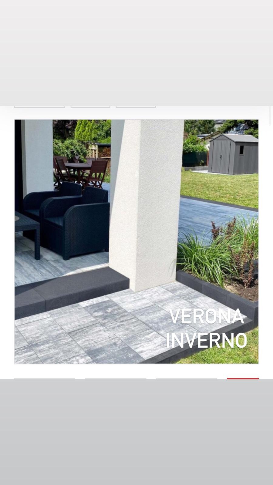 Wykończony taras z szarych płyt Verona Inverno, z czarnym obramowaniem i meblami ogrodowymi. W tle zielony ogród z domkiem narzędziowym.