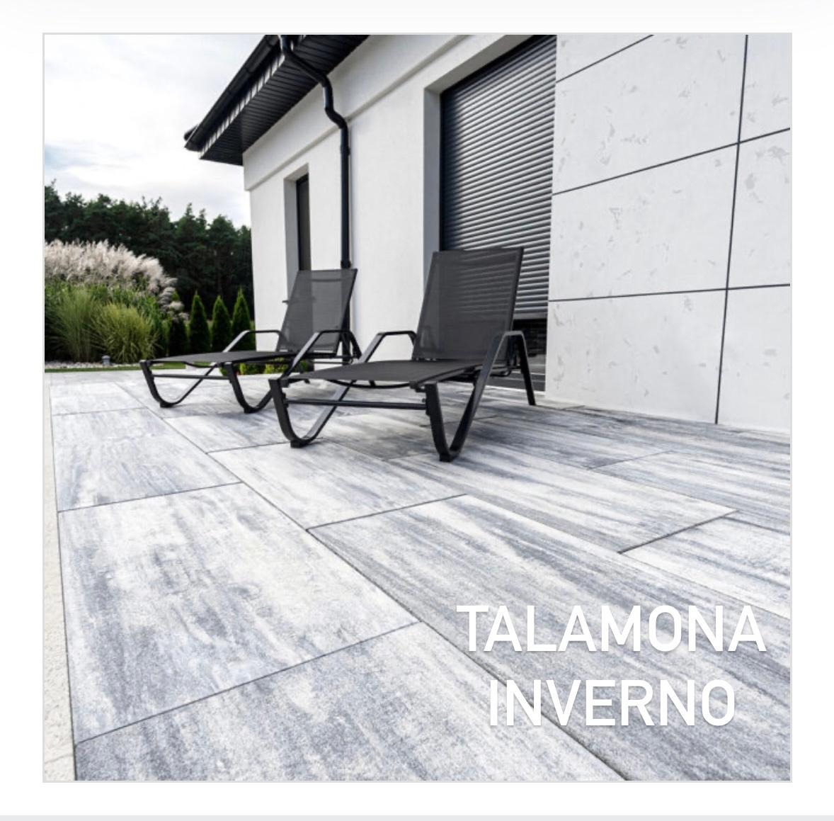 Nowoczesny taras z szarych płyt imitujących kamień, z dwoma czarnymi leżakami. Minimalistyczna elewacja domu z roletami zewnętrznymi w tle.