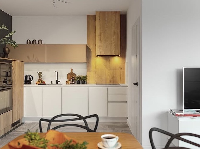 Nowoczesna kuchnia z białymi szafkami i drewnianymi akcentami, widok z jadalni z filiżanką kawy na stole. Minimalistyczny design z roślinami i owocami jako dekoracją.