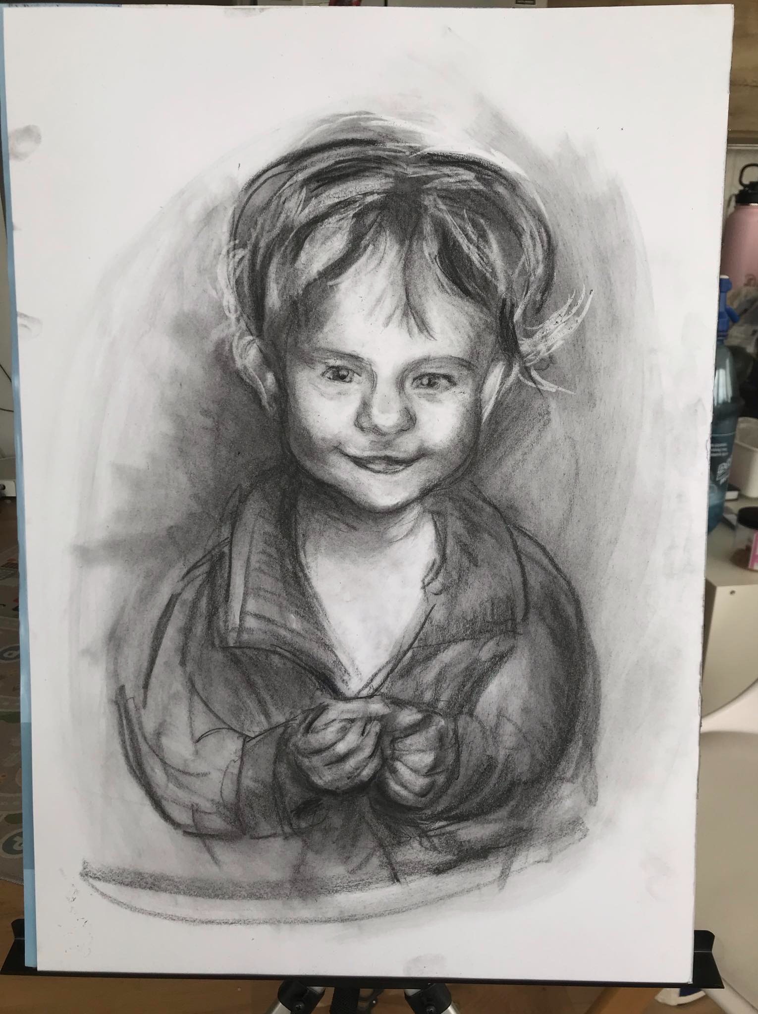 Portret dziewczynki wykonany węglem na białym papierze. Rysunek skupia się na wyrazie twarzy i subtelnych cieniach, tworząc realistyczny i emocjonalny efekt.