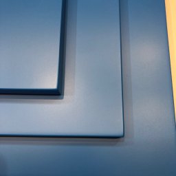 MIĘDZY SĘKAMI JAKUB WIERNICKI-BALCER - Niebieski panel meblowy z frezowanymi krawędziami, prezentujący detale wykończenia i głębię koloru, na jasnym tle.