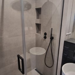 Dan-tech Daniel Gil - Nowoczesna łazienka z kabiną typu walk-in, deszczownicą i umywalką nablatową. Minimalistyczny design, szara kolorystyka, czarne akcenty.
