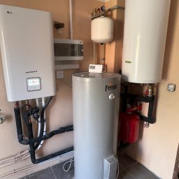 Royal Eco Energy - Zestaw urządzeń grzewczych: pompa ciepła LG Therma V, zbiornik Ferroli, naczynia przeponowe i rury. Kompaktowa instalacja w pomieszczeniu technicznym.