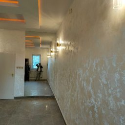 Alians Comfort Bud - Eleganckie wykończenie wnętrza: ściana z efektem dekoracyjnym, podłoga z płytek imitujących marmur, subtelne oświetlenie LED i lustra optycznie powiększające przestrzeń.