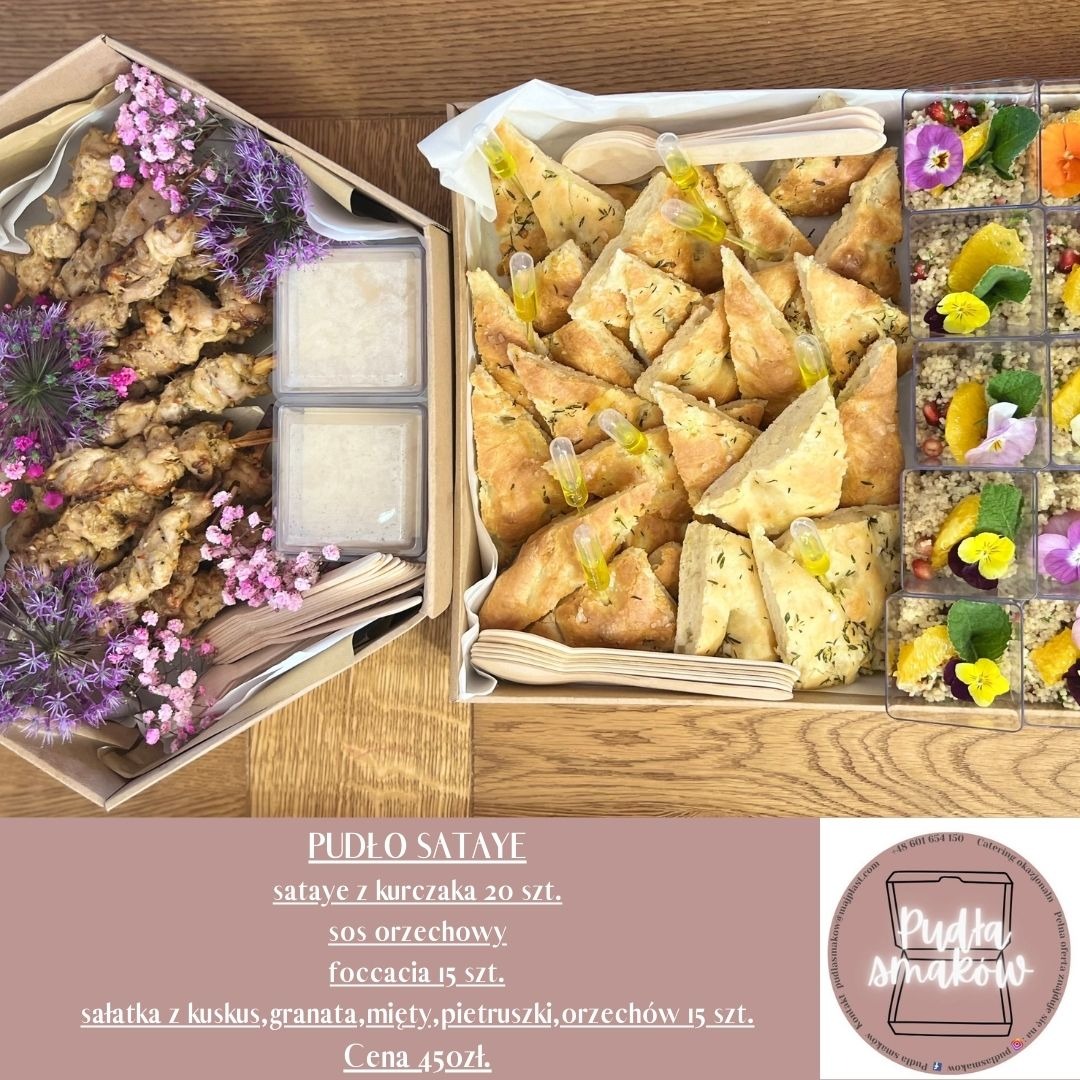 Zestaw cateringowy w pudełkach: szaszłyki z kurczaka z sosem, foccacia z ziołami i sałatka z kuskusu z owocami i kwiatami jadalnymi. Elegancka prezentacja.