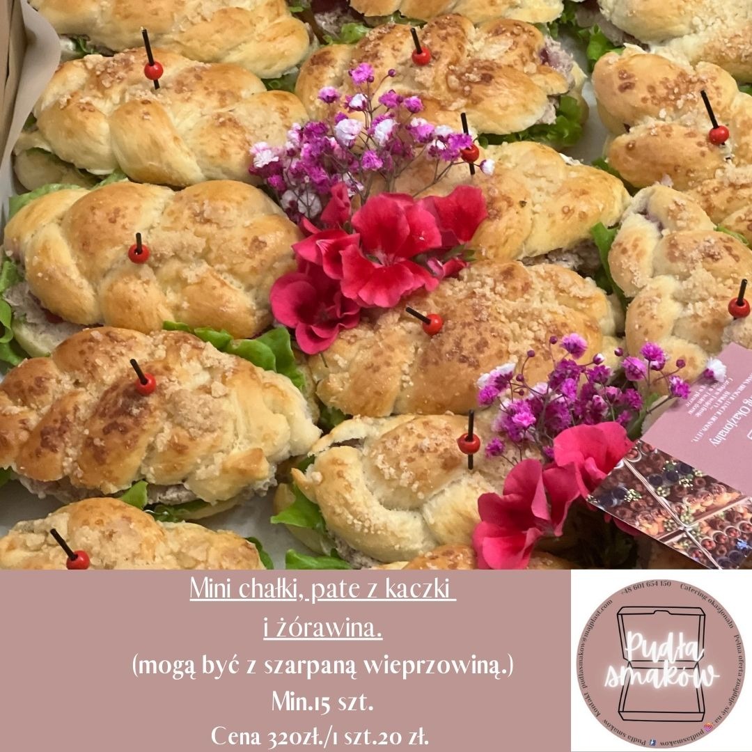 Mini chałki z pasztetem i żurawiną, dekorowane kwiatami w kartonowym pudełku. Eleganckie przekąski cateringowe, idealne na imprezy okolicznościowe.