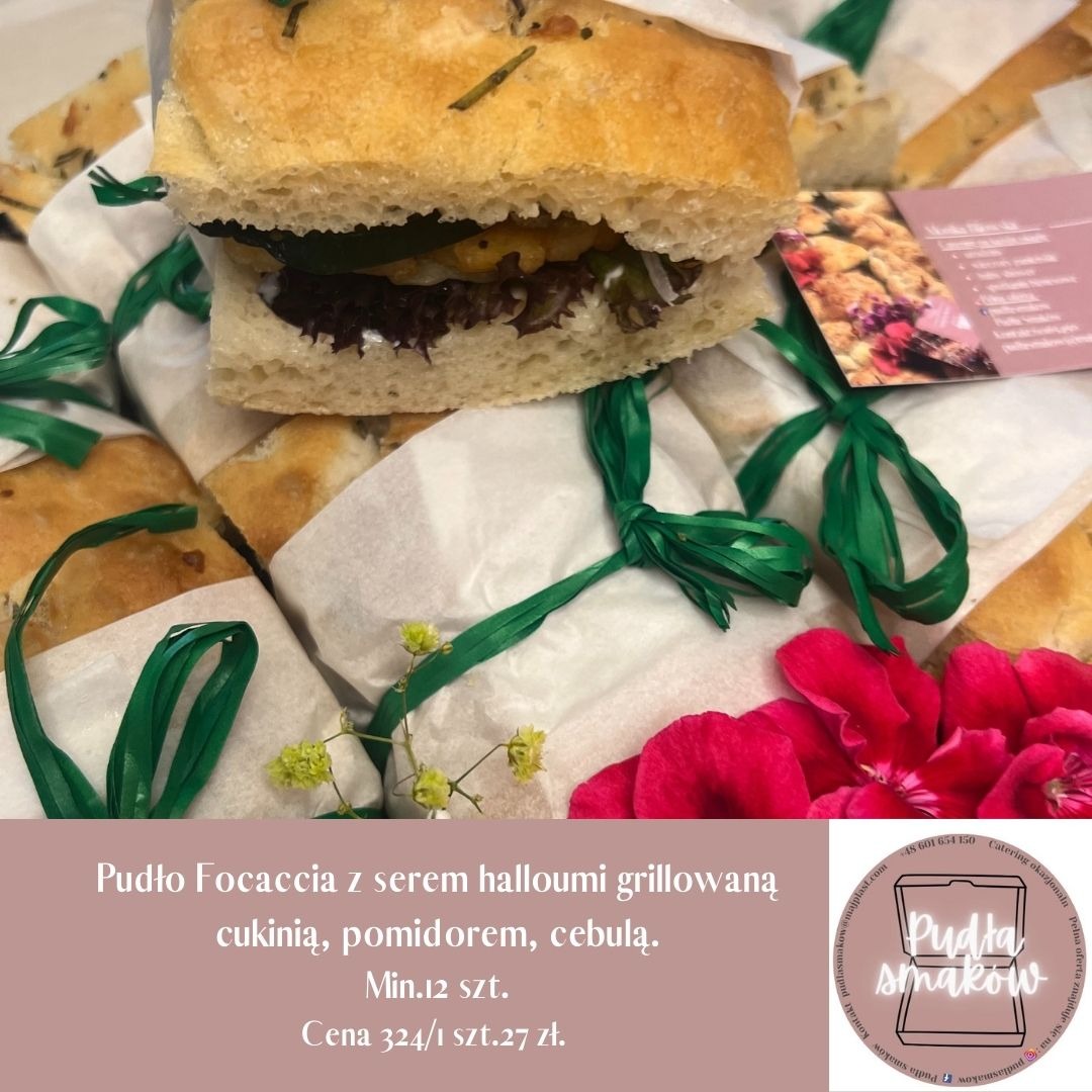 Focaccia z serem halloumi i grillowanymi warzywami, zapakowana w papier i przewiązana zieloną wstążką. Całość tworzy apetyczny zestaw.