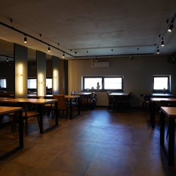 BUDART EXPERT ARTEM SKLIAR - Nowoczesne wnętrze biura z drewnianymi stołami, krzesłami i oświetleniem punktowym. Minimalistyczny design z szarymi ścianami i dużymi oknami.