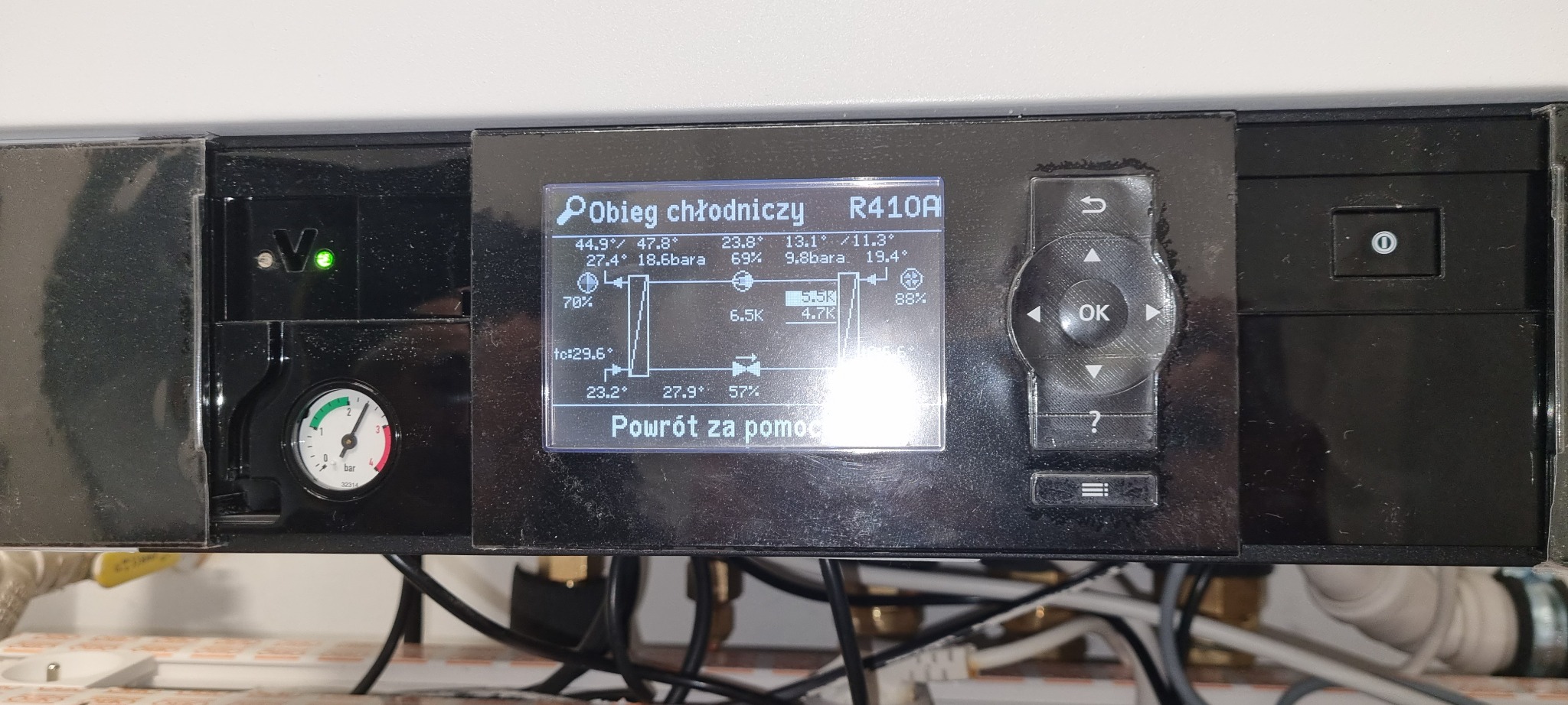 Panel sterowania z wyświetlaczem LCD, prezentujący schemat obiegu chłodniczego R410A z parametrami temperatury i ciśnienia w instalacji. Widoczny manometr.