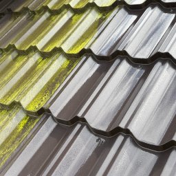CLEAN HOUSE Radosław Myśliwiec - Częściowo wyczyszczona, brązowa dachówka modułowa z widocznym mchem. Porównanie stanu przed i po czyszczeniu, widoczne krople wody.