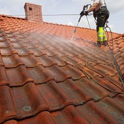 CLEAN HOUSE Radosław Myśliwiec - Mycie ciśnieniowe dachówki w Płocku. Pracownik w uprzęży czyści dach z mchu, używając lancy. Widoczny komin i fragment dachu przed i po czyszczeniu.