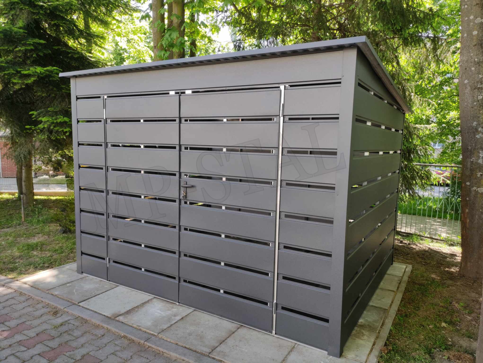 Nowoczesny, szary garaż blaszany z poziomymi panelami, umieszczony na kostce brukowej, z drzewami w tle. Widoczne detale konstrukcyjne i estetyczne wykończenie.