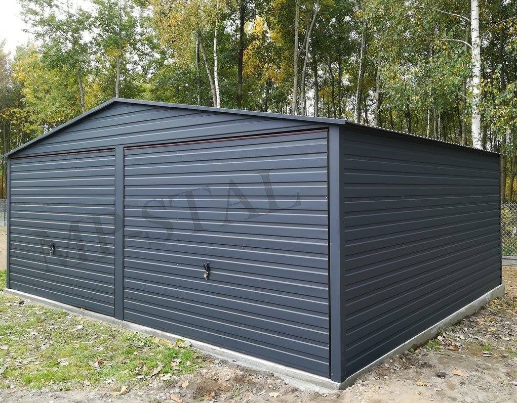 Grafitowy garaż blaszany dwustanowiskowy z dachem dwuspadowym, widoczny na tle drzew. Gładka elewacja z poziomymi przetłoczeniami i dwoma parami drzwi.