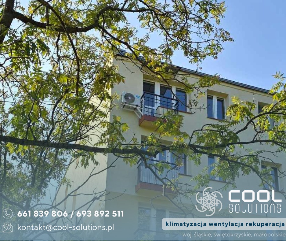 Klimatyzator na elewacji budynku mieszkalnego, widoczny przez gałęzie drzewa. Logo firmy Cool Solutions w rogu zdjęcia.